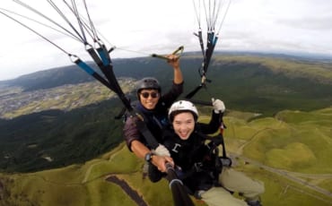 Mika et son instructeur, volant en parapente au-dessus du mont Aso une des activités de plein air à pratiquer à Kumamoto