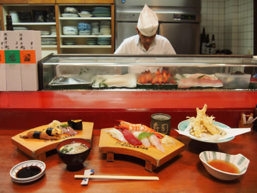 Repas de sushis au comptoir devant le maître à Saiki