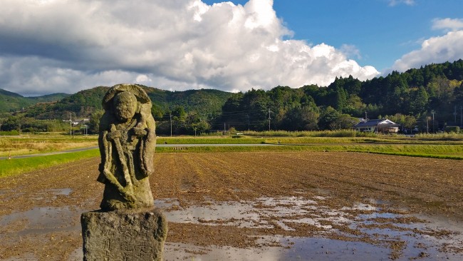 Tano Kansa - picture of the Tano Kansa and a dirt field with trees far ahead.