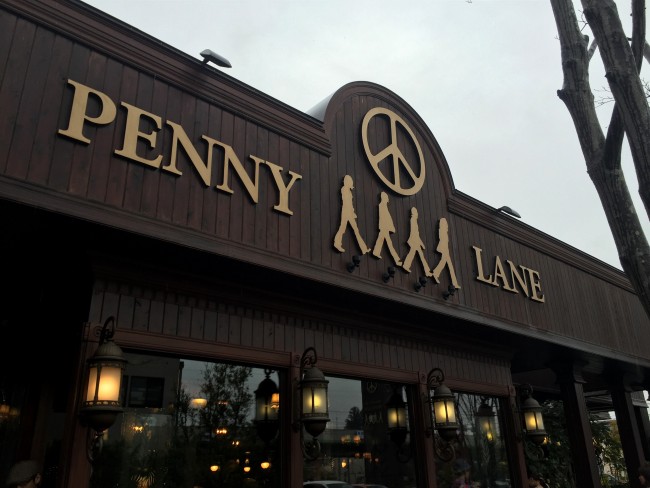 Exterior sign featuring silhoutted bandmates introduces the Beatles theme at Penny Lane Bakery cafe, Utsunomiya