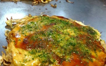 Juju Okonomiyaki restaurant where Okonomiyaki is being grilled.