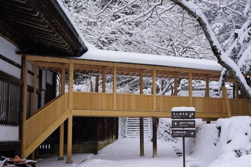 A simple bridge along a walking trail in Takayama covered in snow. 