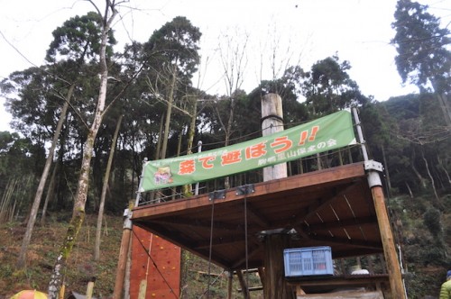 A zipline post Nozaki-san built with a sign that reads: "Let's play in the woods!"