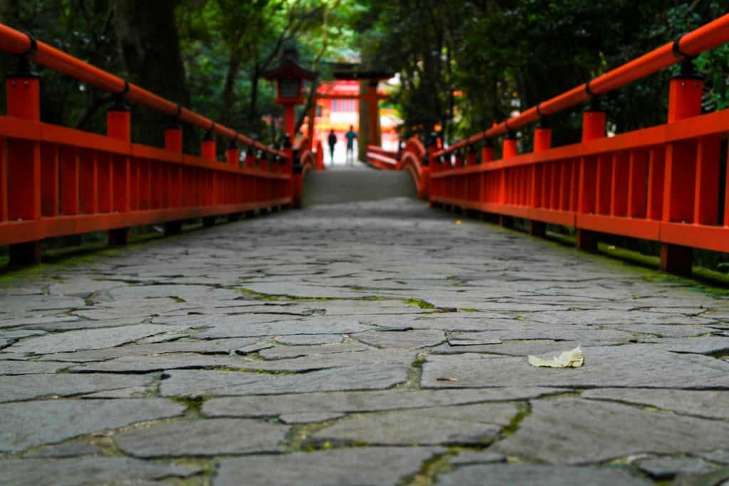 traditional stone and red bridge to Japanese shrine in Japan