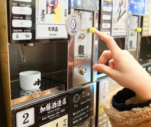 Getting sake from a vending machine at Ponshukan, Echigo-Yuzawa Station.
