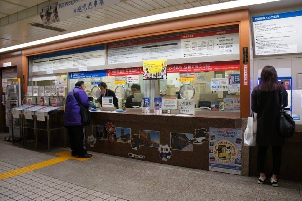 Seibu Shinjuku Station Ticket Desk: Tickets for the Red Arrow train are at the red desk.