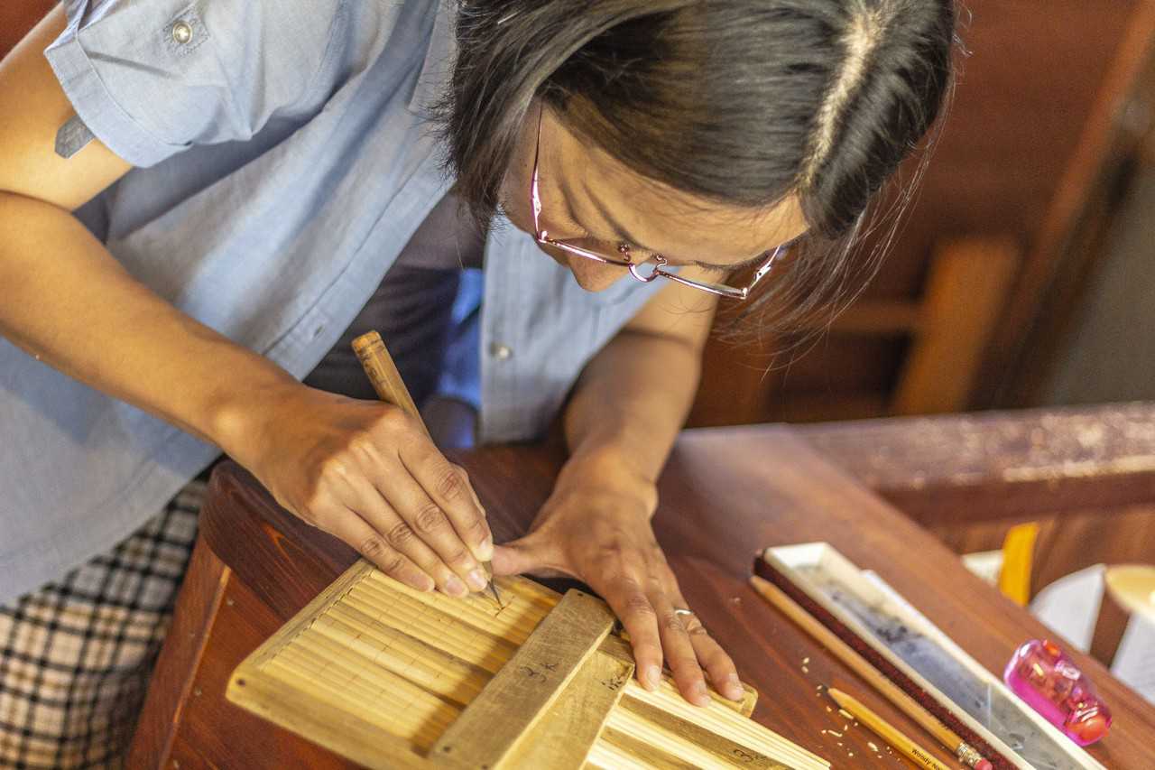 woman carving chopsticks in japan