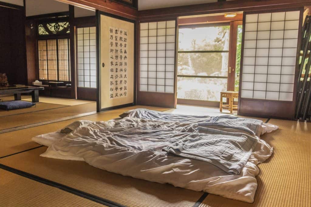 two futons laid out in a large tatami room in Japan