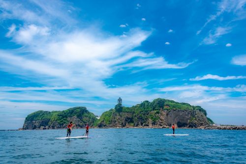 People practice paddle board on the ocean with Enoshima view