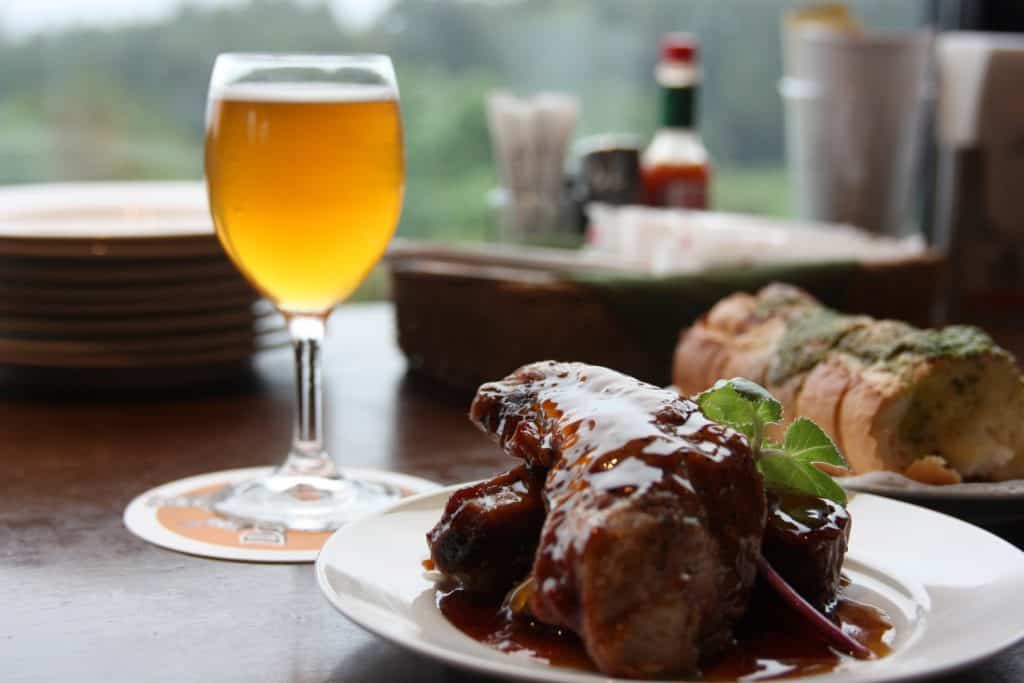 meat dish next  to glass of beer in a japanese restaurant and bar