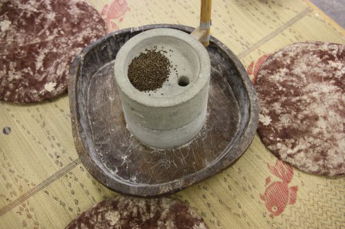 Grinding soba into flour for soba noodles.