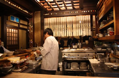 A chef prepares dishes at Mingeichaya, an izakaya restaurant in Kurashiki, Okayama.