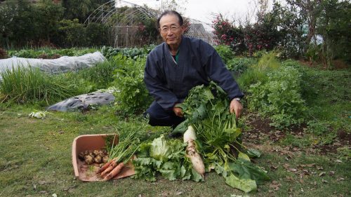 An Izumi farmer showing some of the produce grown on his farm.