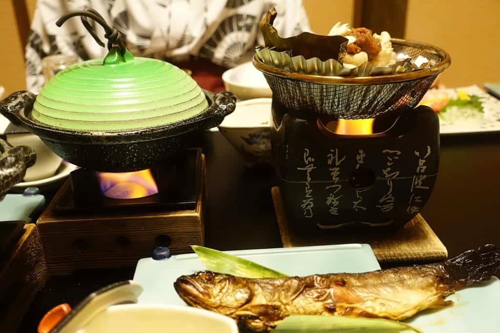 Dishes are heating on the table of the private dining room of the ryokan Yunoyado Motoyu club