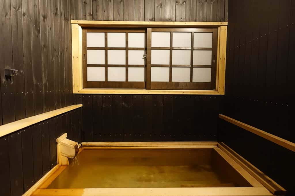 Private onsen bath seen from the front of a room of the ryokan Yunoyado Motoyu club