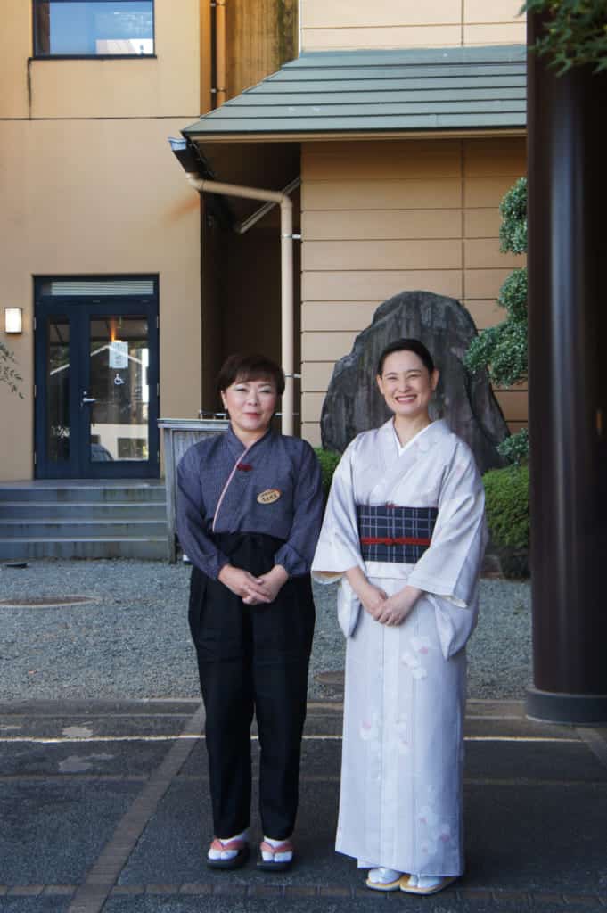 Two female ryokan staff, one dressed in kimono