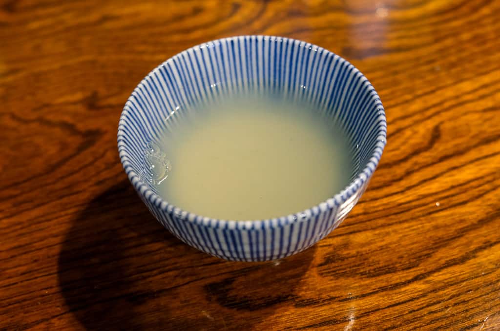 Drinking soba yu water at Soba buckwheat noodle restaurant in Izushi Castle town in Hyogo, Japan