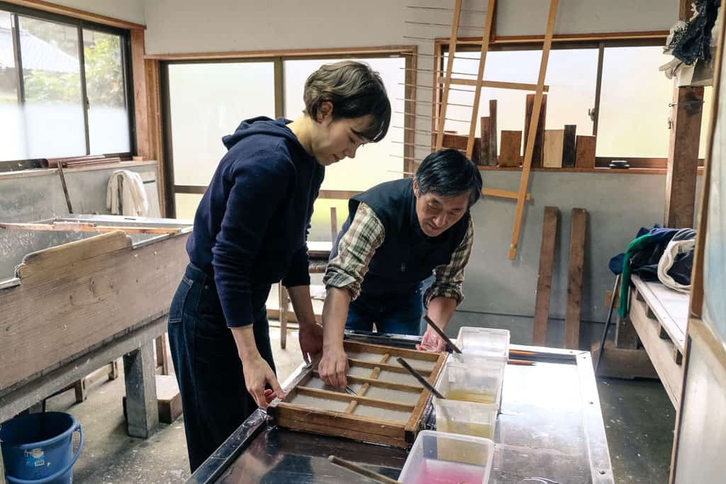 Mr. Yamamoto checks Mika's Japanese kurotani washi paper in Kyoto