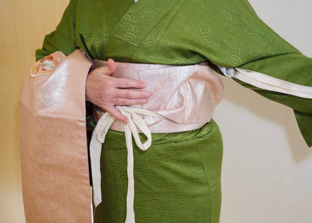tuck the thin end of the obi under the koshi-himo to keep it out of the way