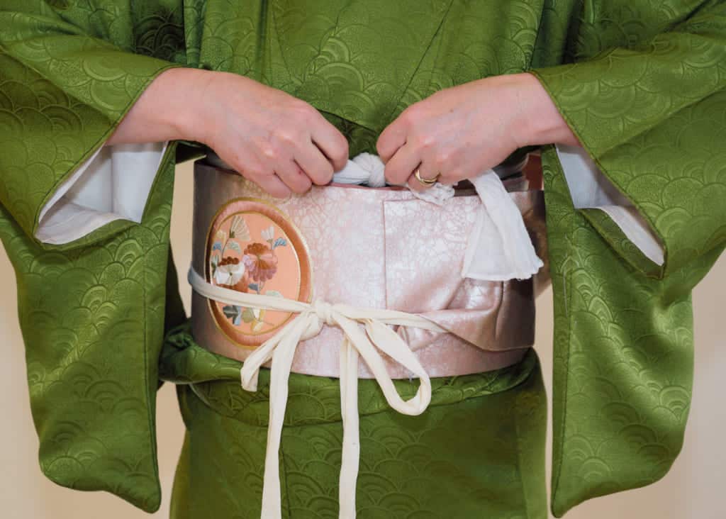 tuck the sash of the obi-makura under the obi