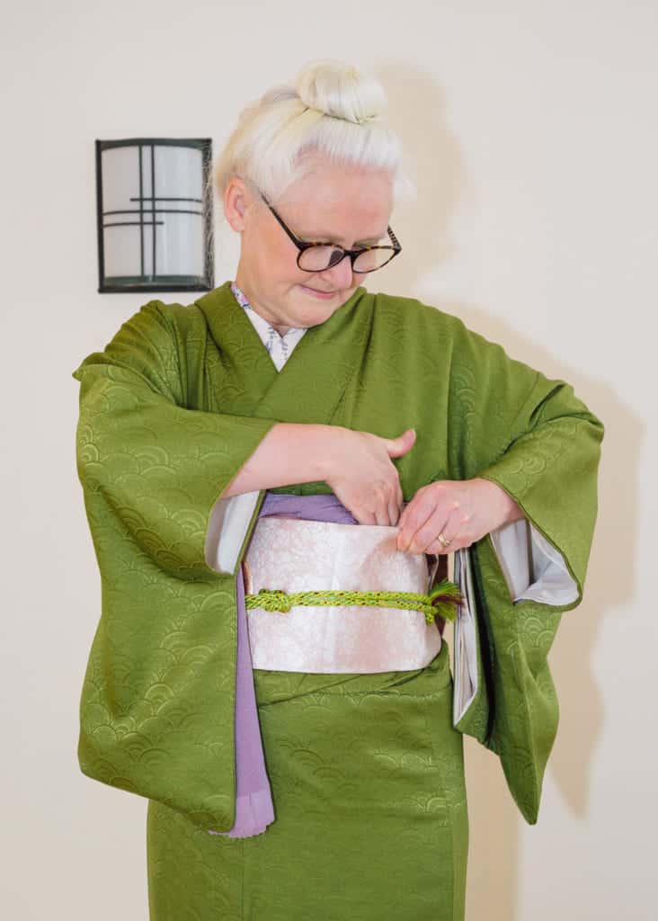 tuck the right side of the obiage down into the top of the obi