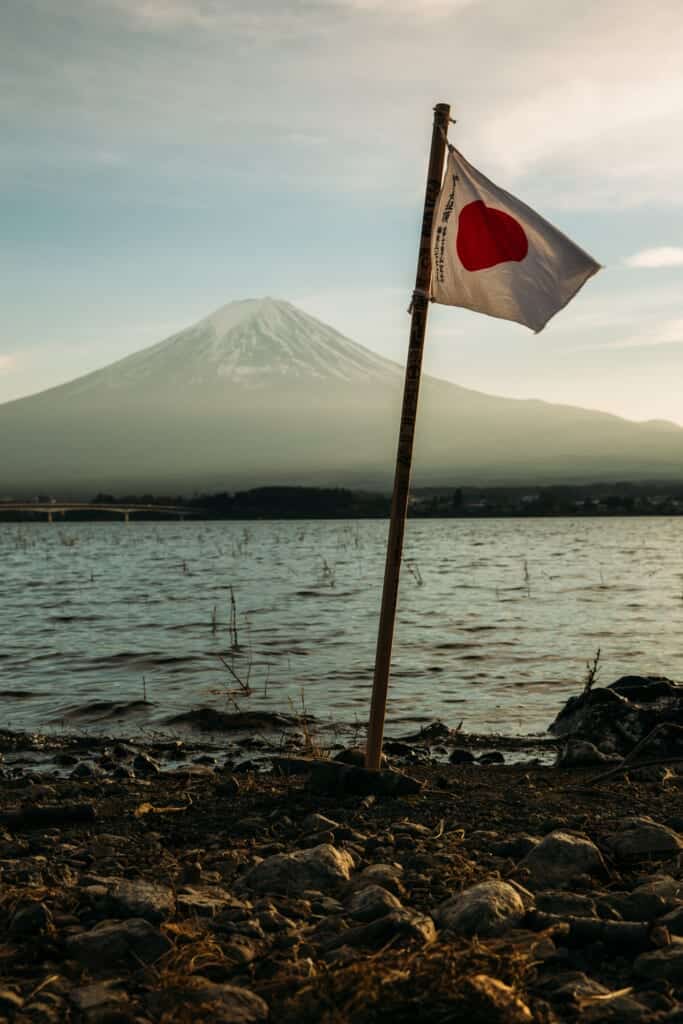 A japanese flag waving in front of Mount Fuji