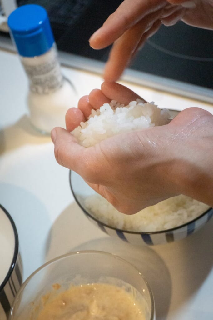 Press the rice with your hands in order to make an onigiri