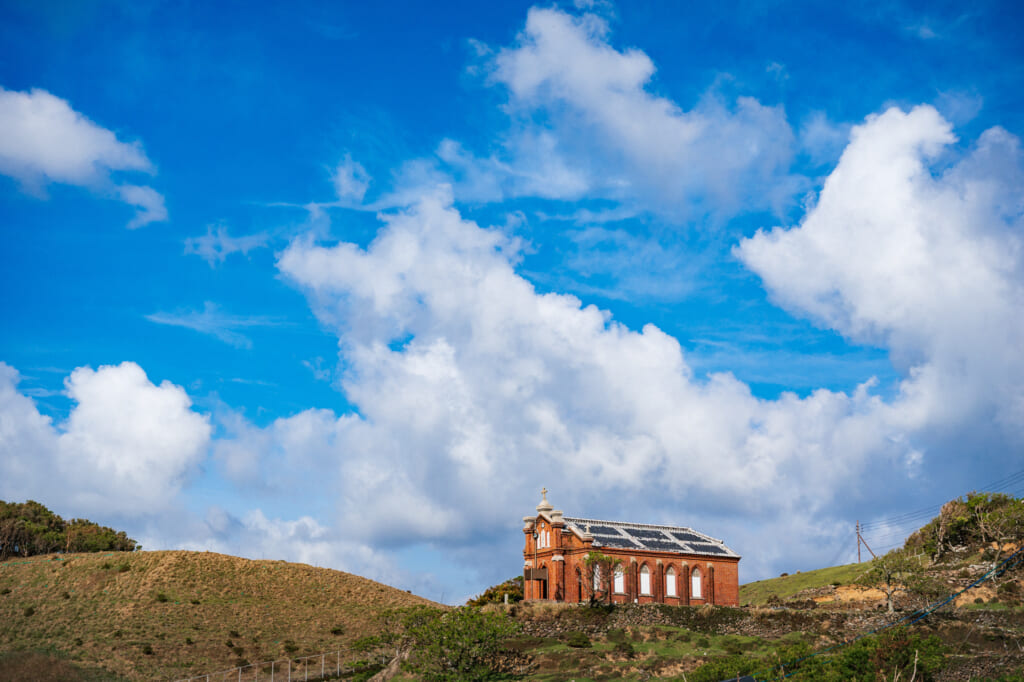 Former Nokubi Church stands on a hill with blue sky and big clouds