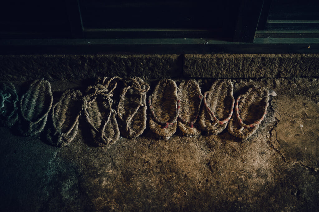 Old straw sandals on a dirt floor of a house on Nozaki Island in Japan