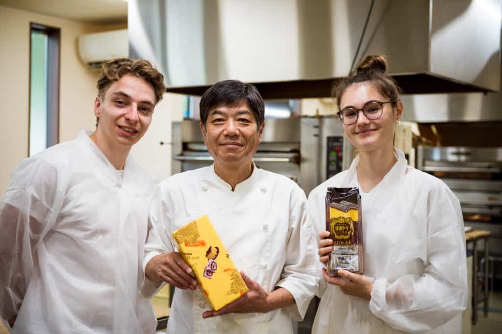 2 people posing with packets of yoshu cakes