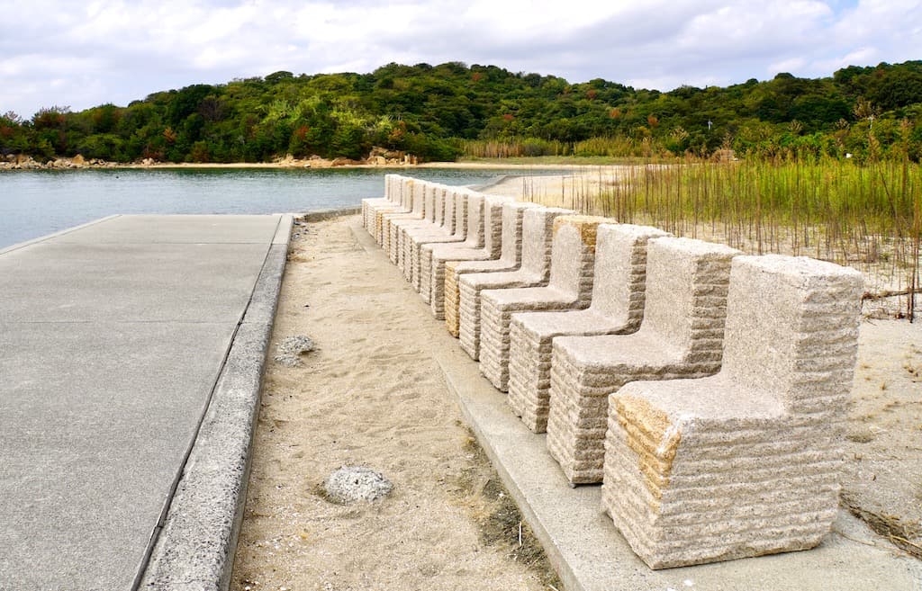 Stone chairs face the beach