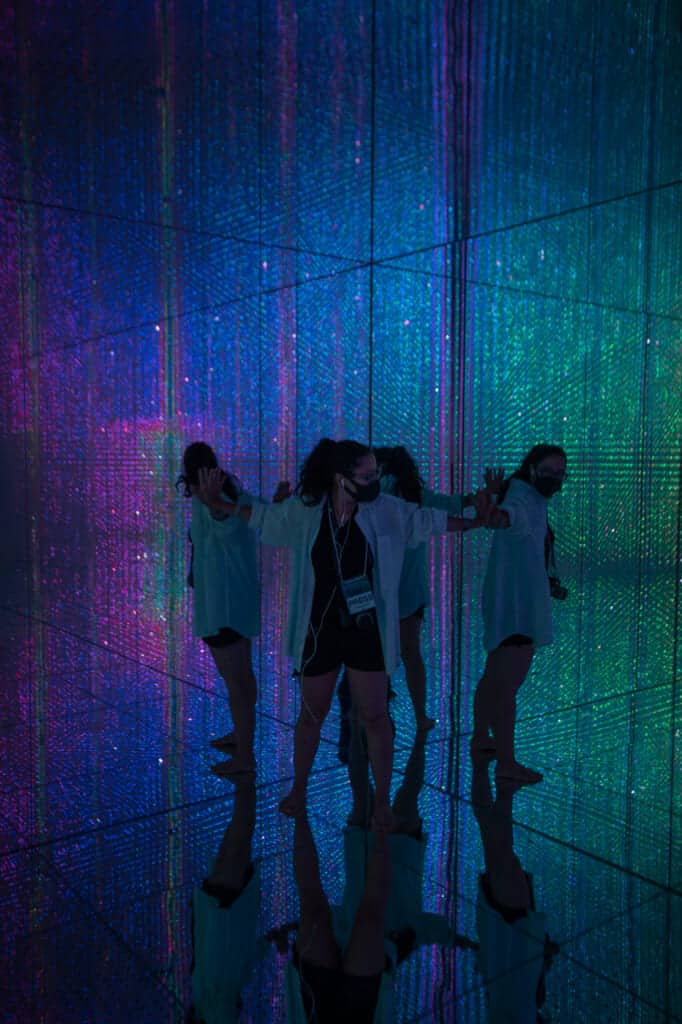 woman surrounded by rainbow illumination at teamLab Planets in Tokyo