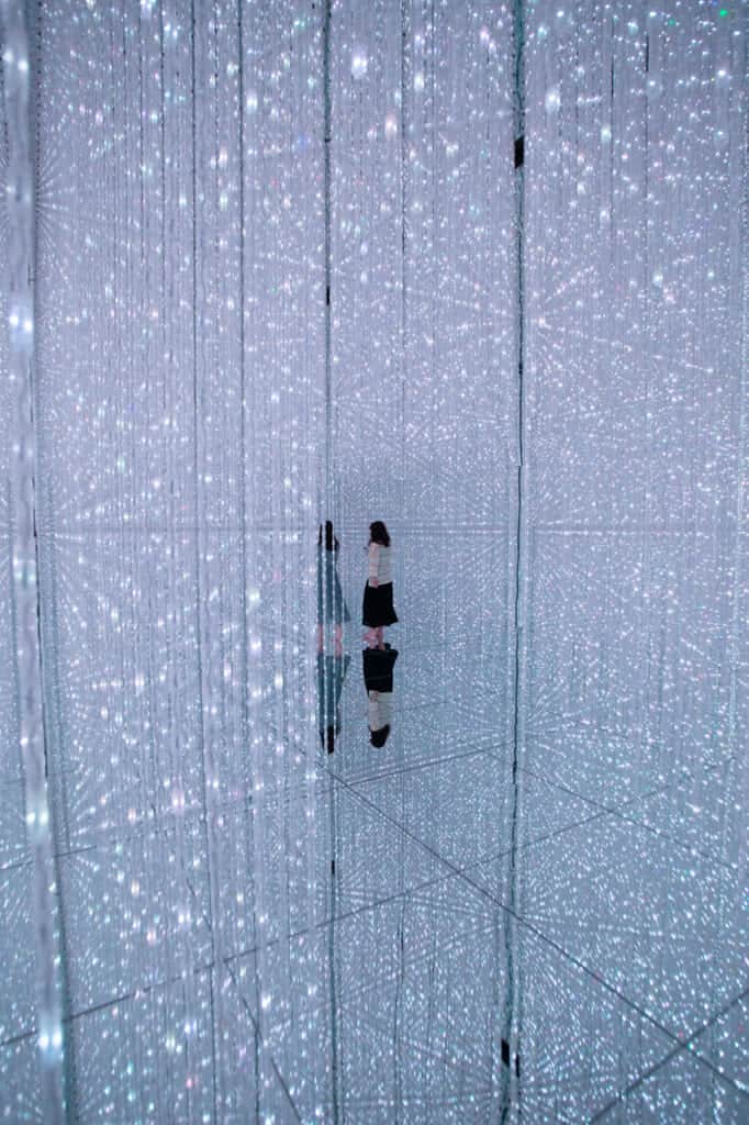 two women wandering around crystals of light at teamLab Planets in Tokyo
