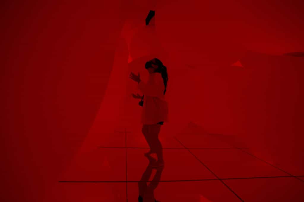 woman looking at the red spheres of light at teamLab Planets in Tokyo