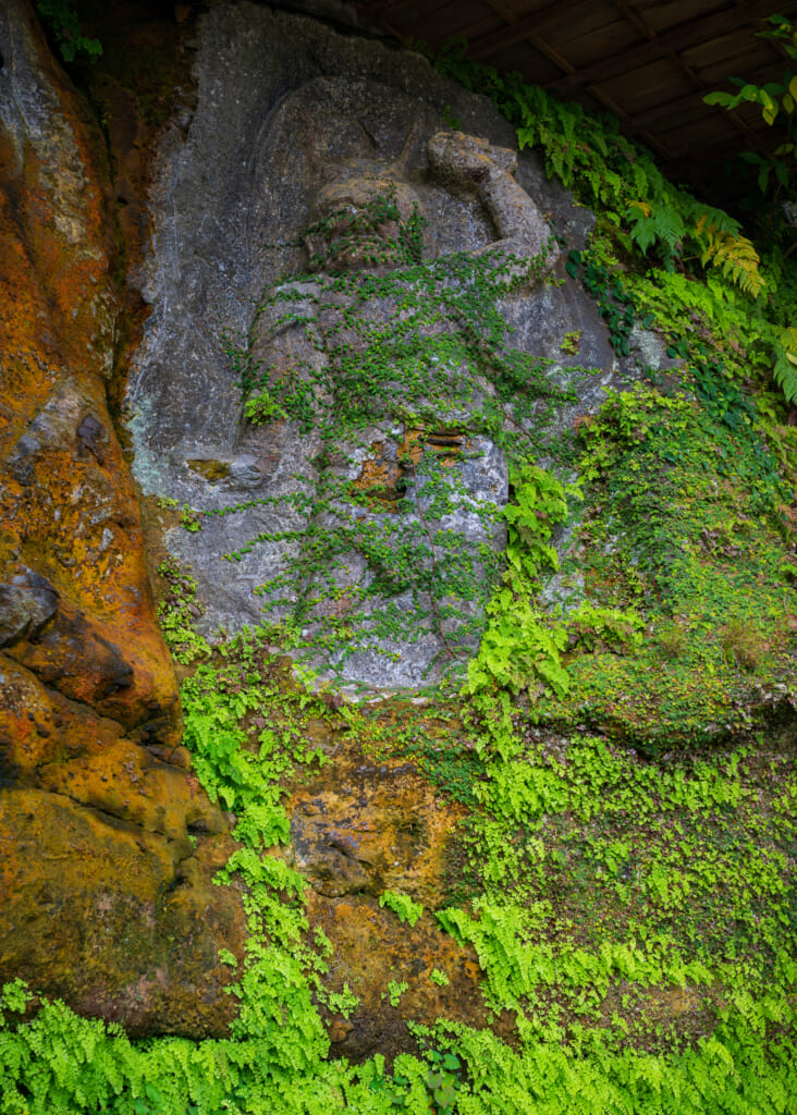 moss covered buddhist statue in usuki, kyushu