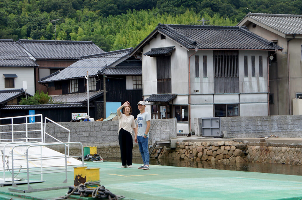 Two local residents waving from Manabeshima, a cat island in Japan