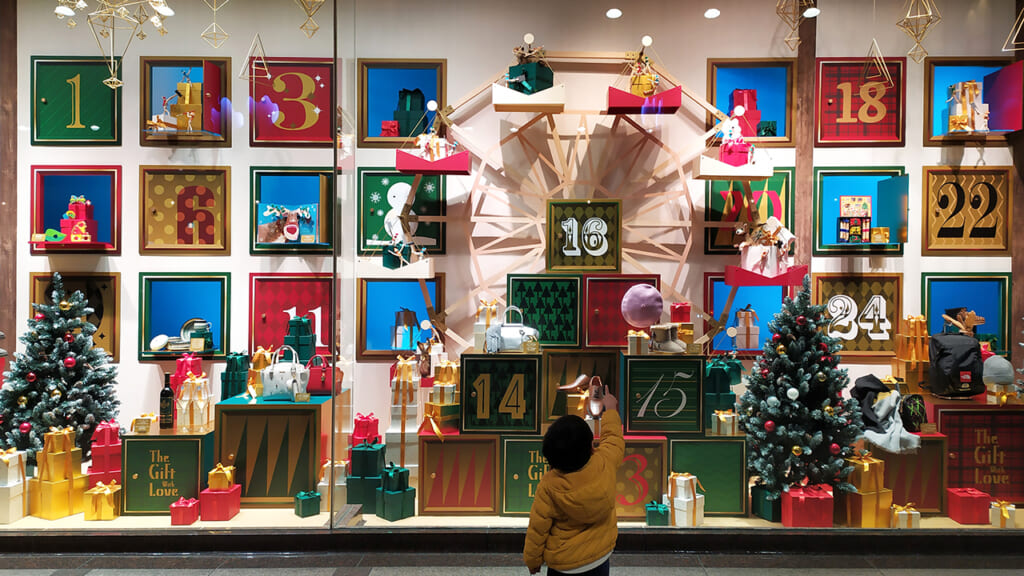 A child in front on a shop window during Christmas Season