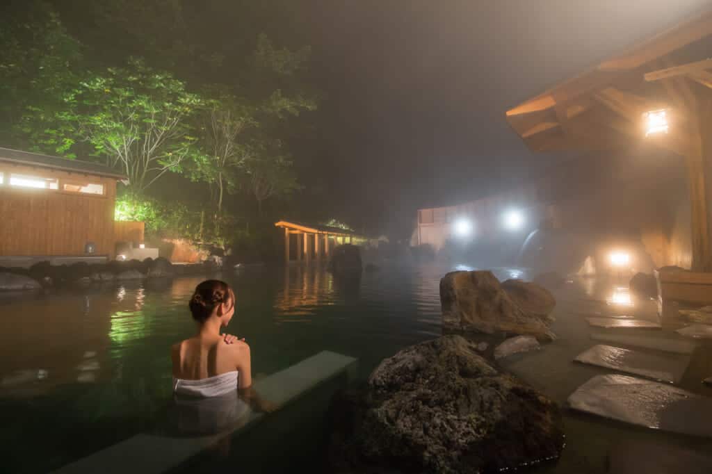 woman taking a bath in onsen hot springs in kusatsu, Gunma, Japan