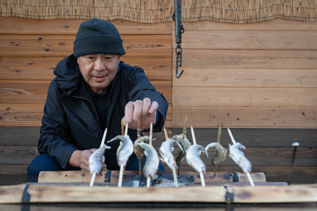 Mr. Ogura grills skewered Ayu fish over charcoal 