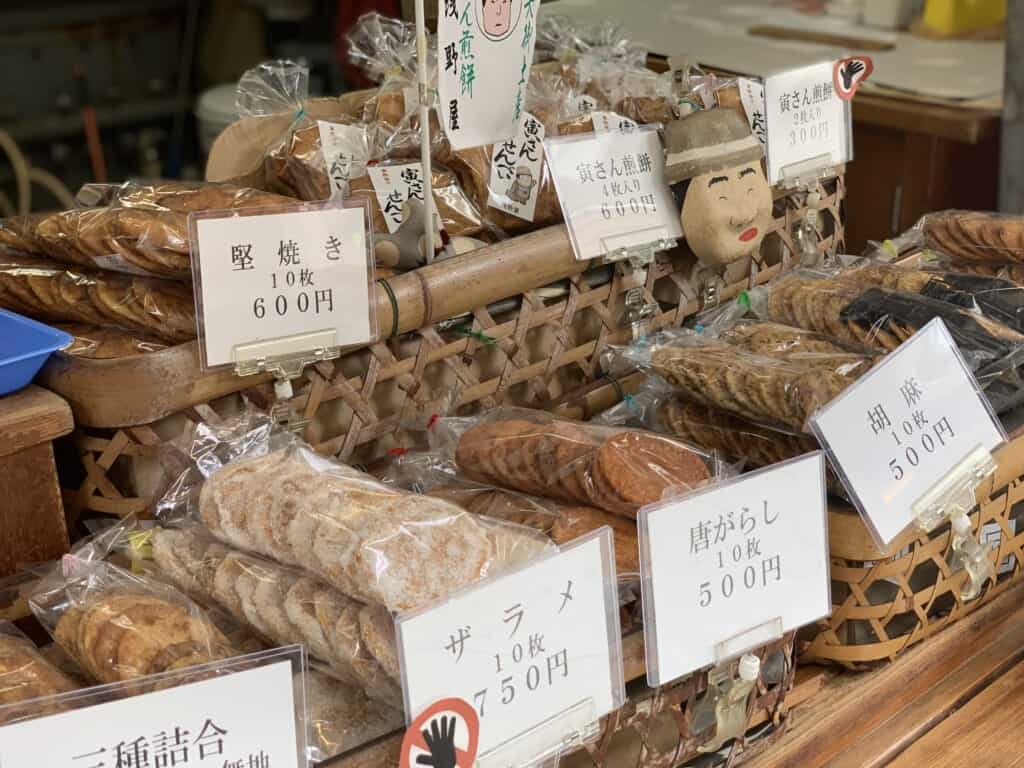 Multiple baskets filled to the brim with different flavors of Japanese rice crackers at Asanoya.