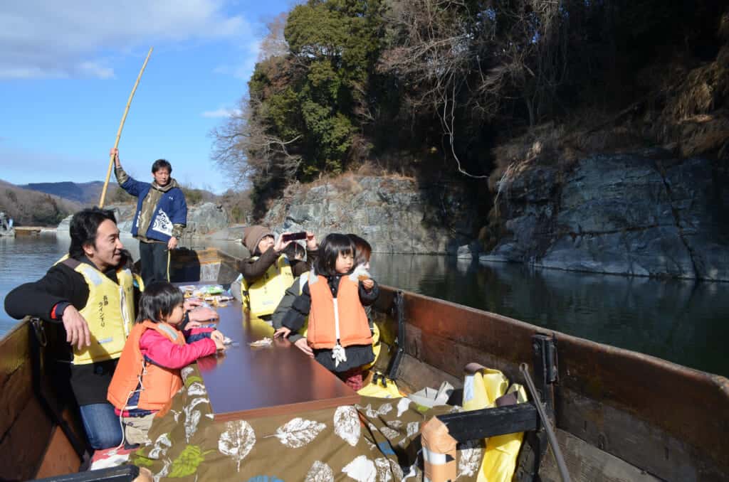 People sitting in a kotatsu heating table in a river boat in Japan