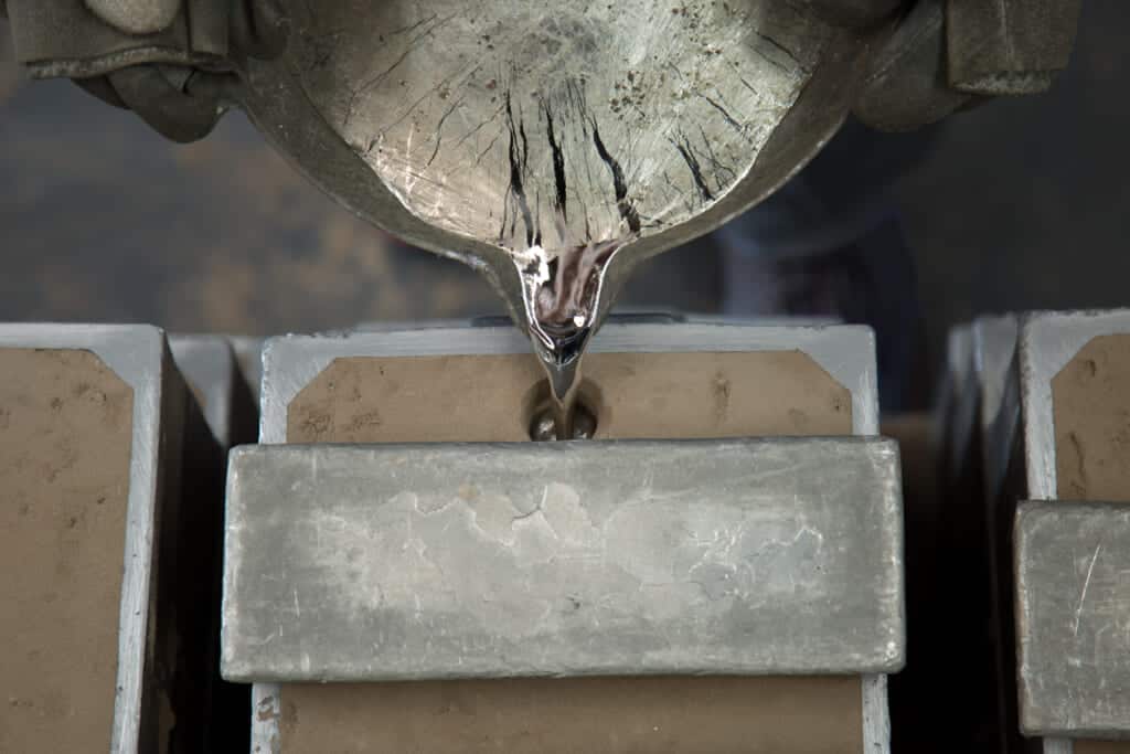 melted tin poured into a sand mold