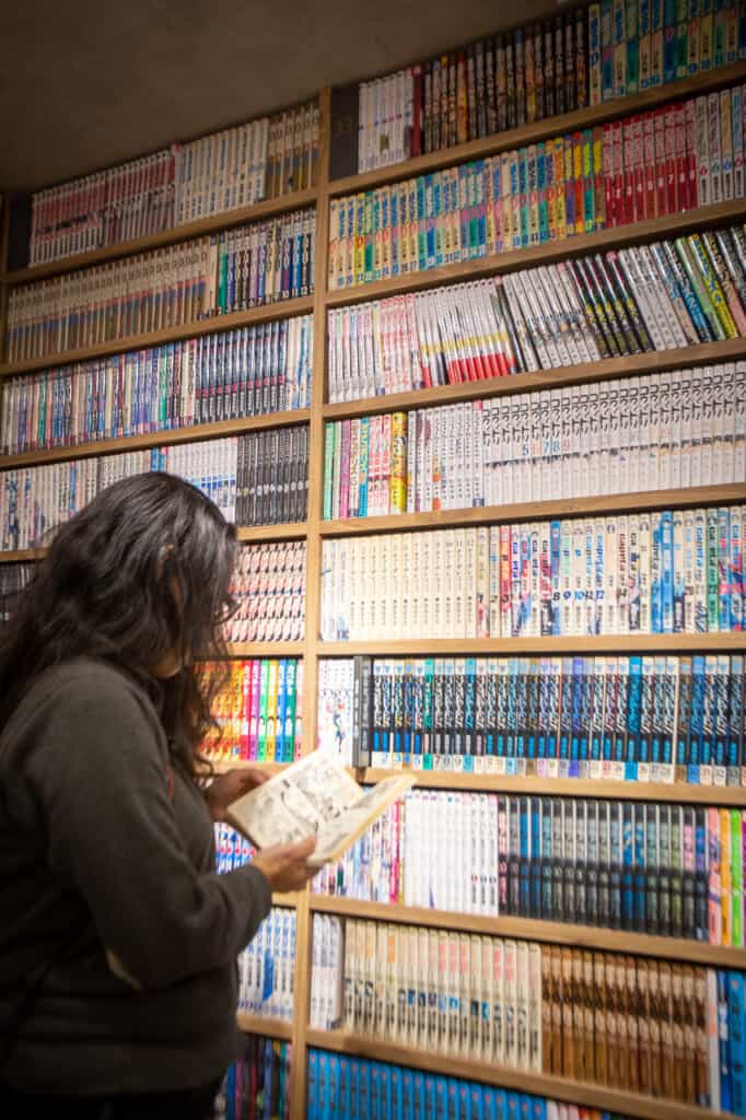 A girl choosing a manga comic in a manga cafe