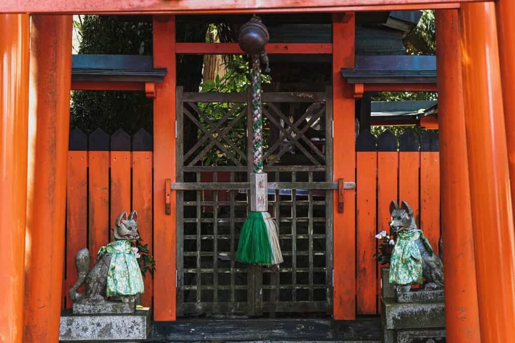 Inari shrine with vermillion torii and fox statues