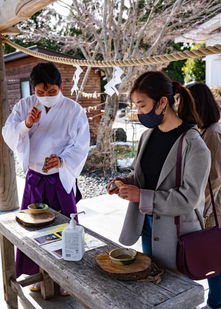 Japanese shinto shrine priest demonstrates purification near tokyo