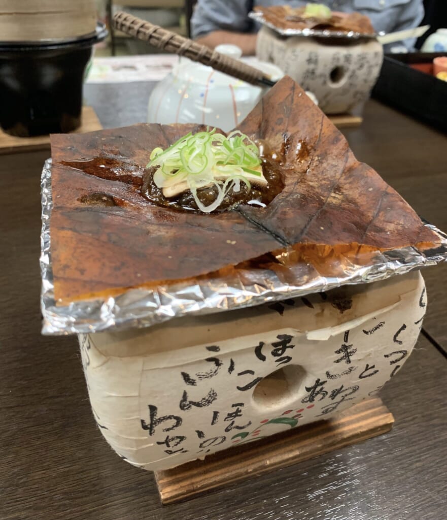 Traditional Japanese meal withHoba miso on a magnolia leaf cooking over a tabletop grill