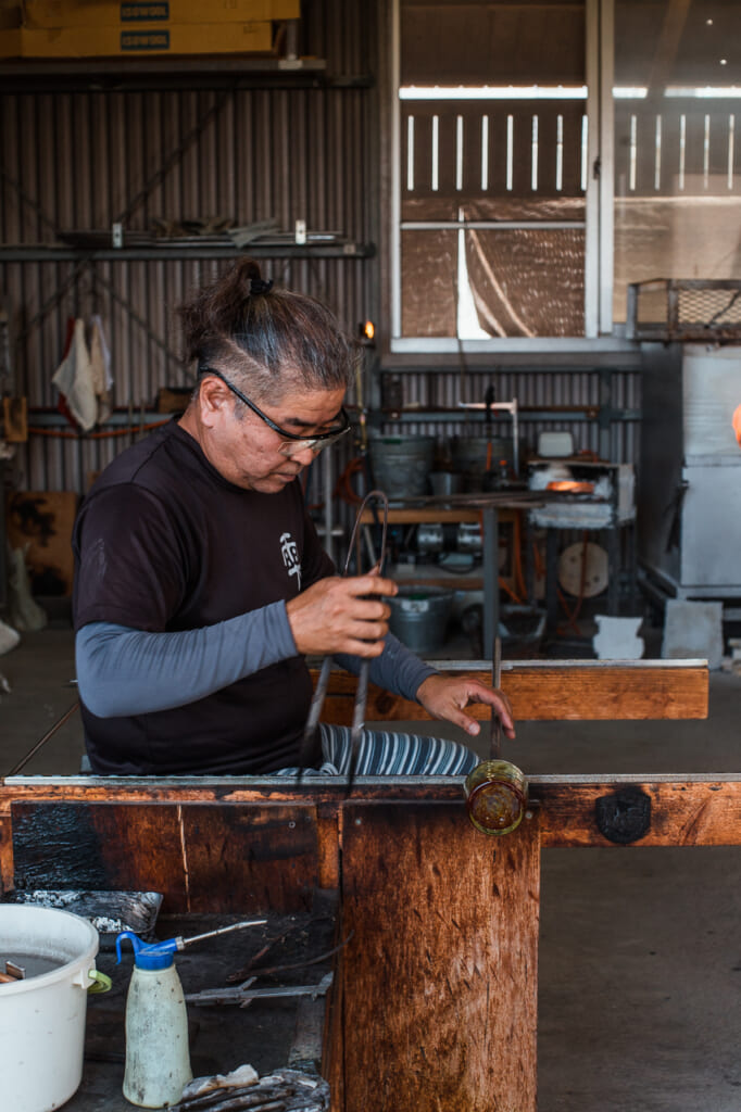 Japanese craftsman, kaneshi shaping a glass in Japan
