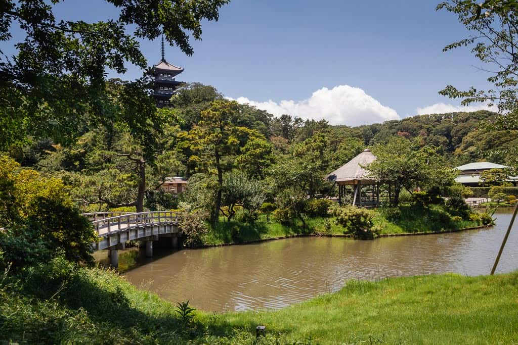 Japanese pagoda overlooking pond in garden in Japan