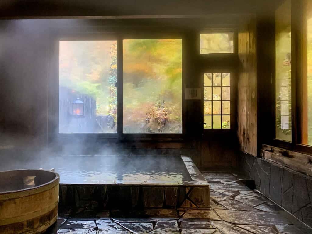 Onsen bath with large windows and forests scenery