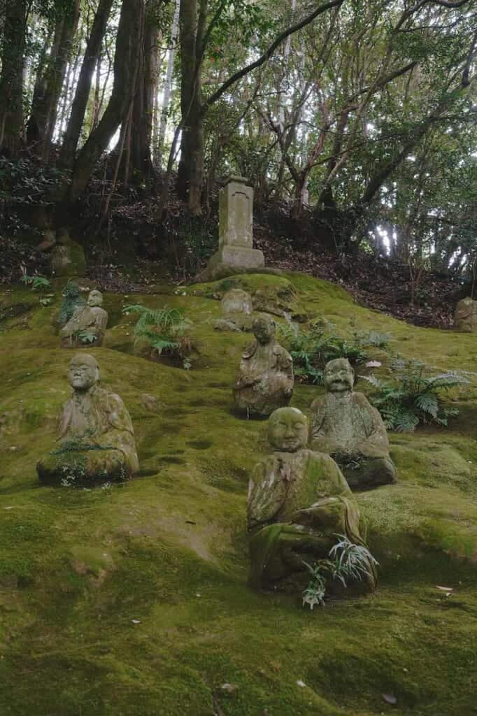 Statues of Buddha disciples covered in moss in Japan